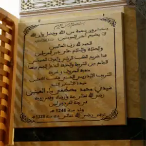 Plaque commémorative en marbre gravée en calligraphie arabe, indiquant l'emplacement du mausolée du cheikh et érudit soufi Ma El Aïnin.
