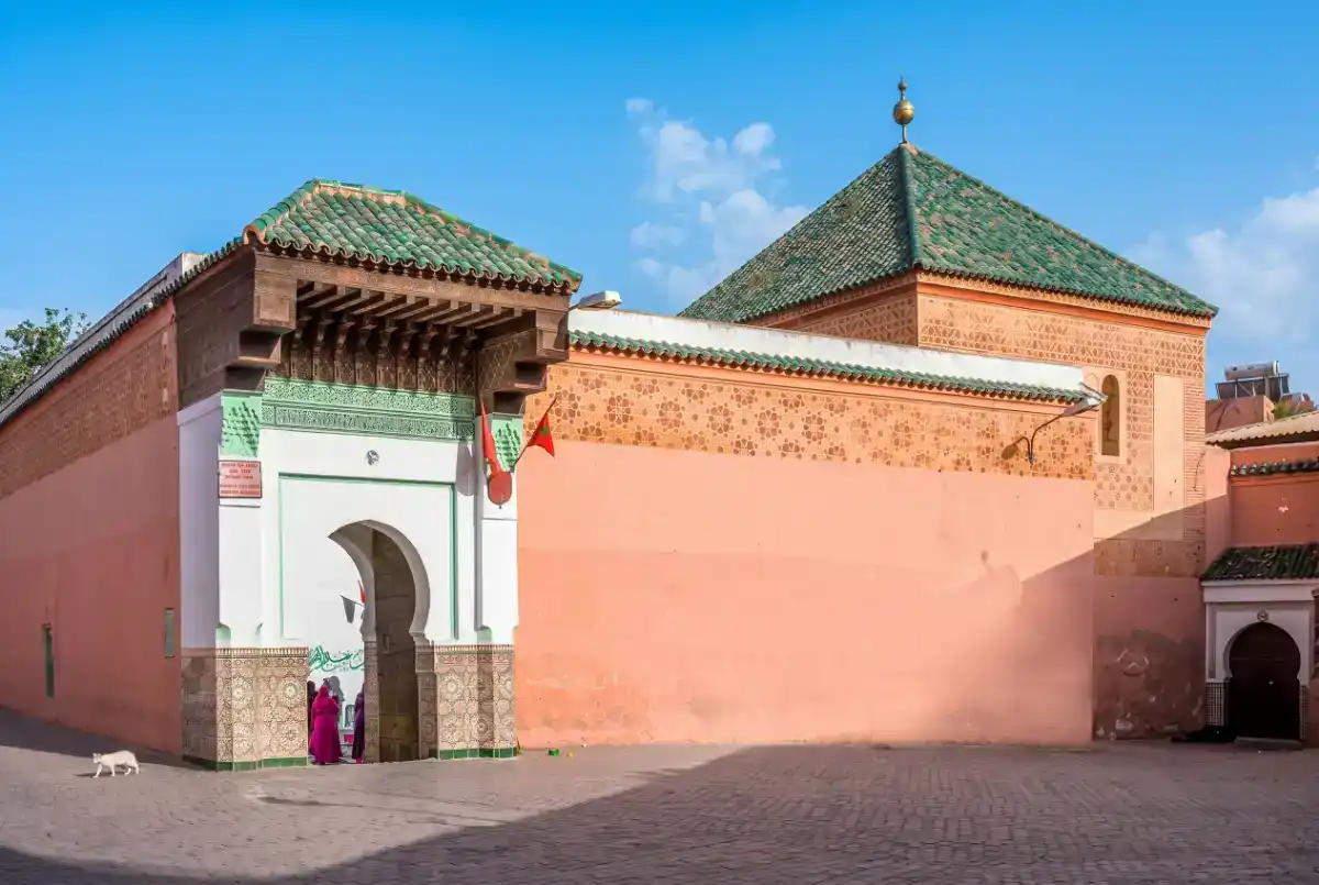 Entrée du mausolée de Sidi Abdellah el-Ghazouani à Marrakech, montrant l'architecture de la koubba avec ses tuiles vertes et ses murs ocre caractéristiques de la médina.