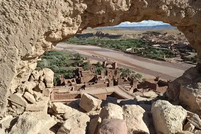 ksar-ait-ben-haddou-maroc-patrimoine-unesco Vue panoramique du Ksar d'Aït-ben-Haddou au Maroc, montrant les bâtiments en terre crue (argile) et les tours fortifiées contre la colline.