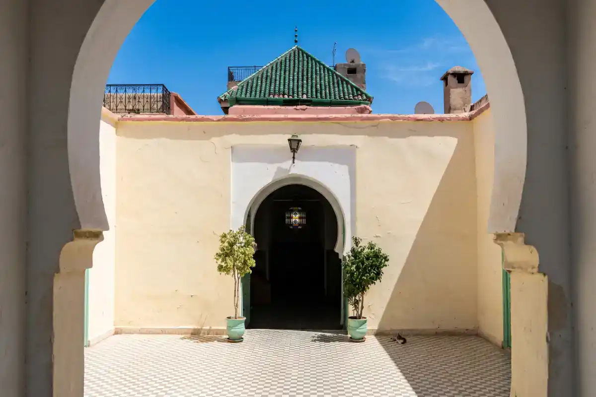 Entrée principale de la Zaouïa de Sidi Youssef Ben Ali à Marrakech, avec ses murs ocre, ses portes sculptées et ses motifs de zelliges traditionnels.