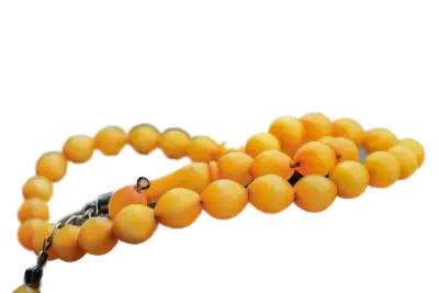 chapelet-tasbih-ambre-interieur Orange beaded necklace with a dark metal clasp laid out on a contrasting background.
