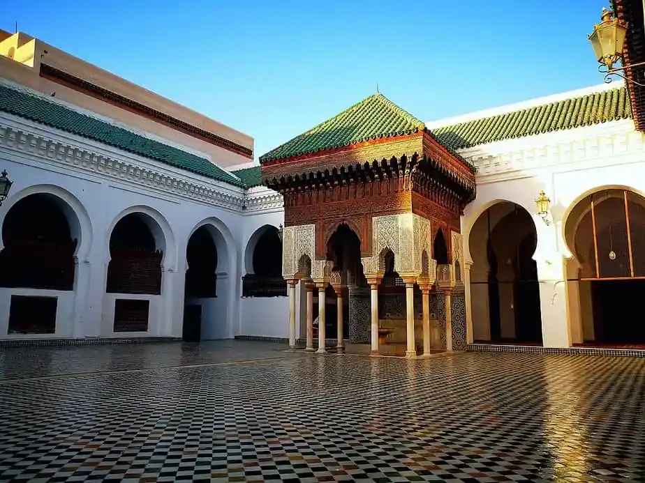 Cour intérieure et pavillon de la Mosquée Al-Qarawiyyin à Fès Cour en marbre et zelliges de l'université Al-Qarawiyyin à Fès avec son pavillon traditionnel en bois sculpté et arcs blancs.