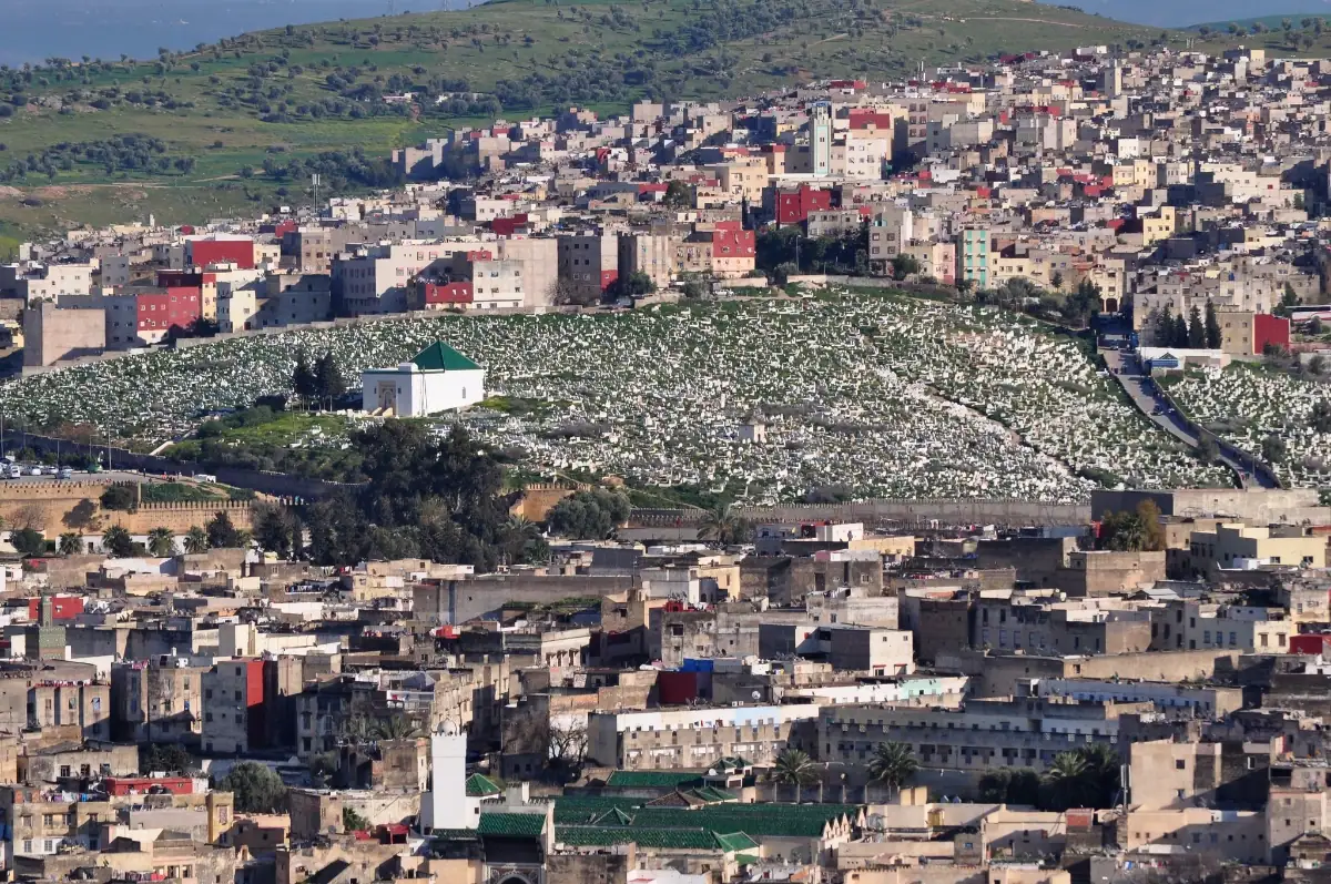 Mausolée de Khayrouna al-Fassia et vue sur Fès Mausolée blanc au toit vert de Khayrouna al-Fassia au cœur du cimetière de Bab Ftouh, surplombant la médina de Fès.